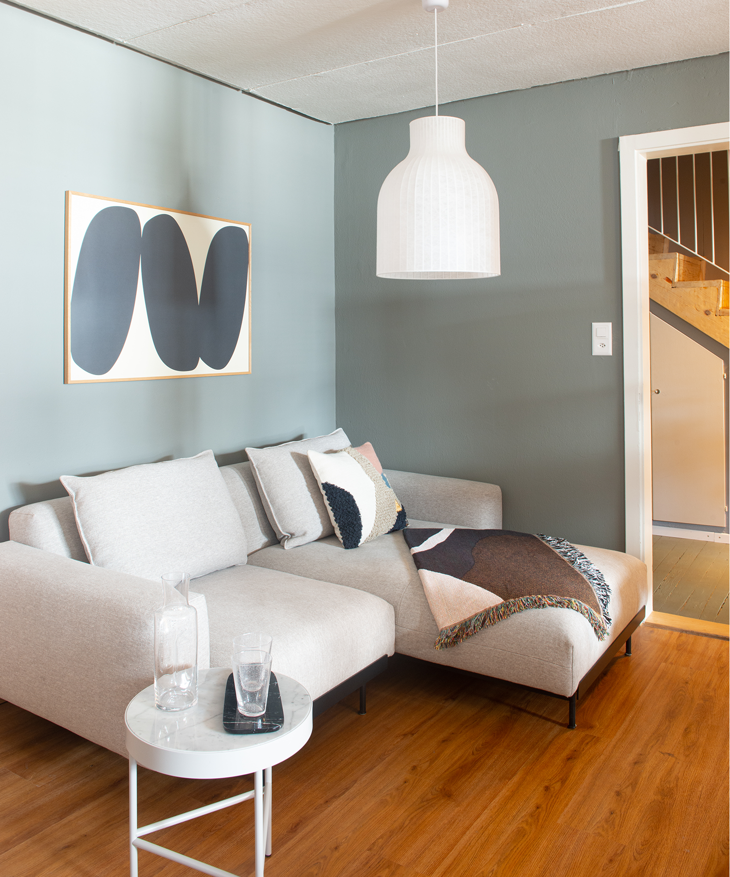 Wohnzimmer mit grau-grüner Wand, Muuto und Ferm Living Mobiliar